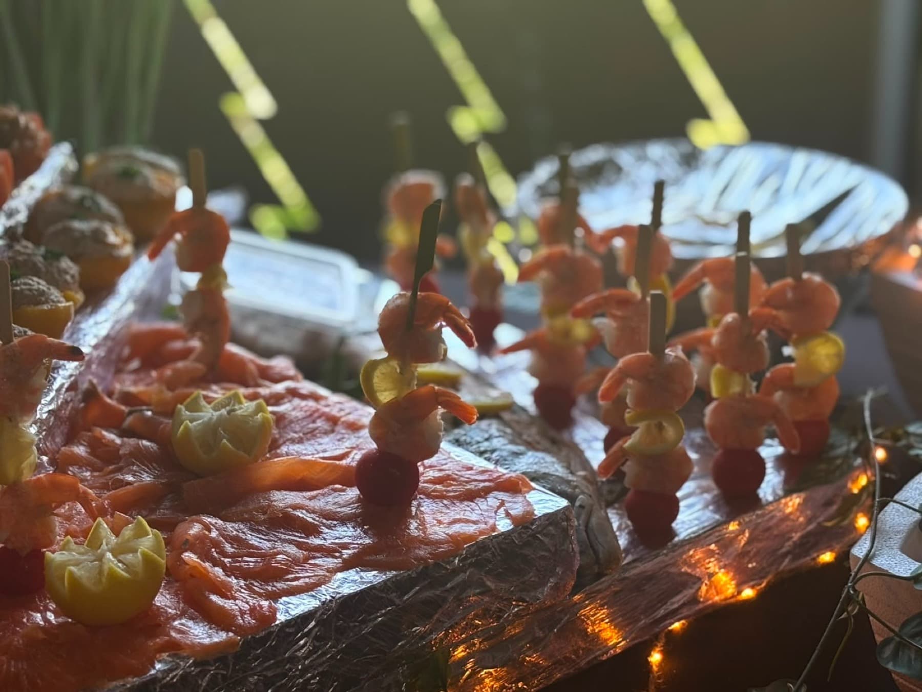 Brochettes de scampis et saumon fumé sur un buffet aux lumières chaudes
